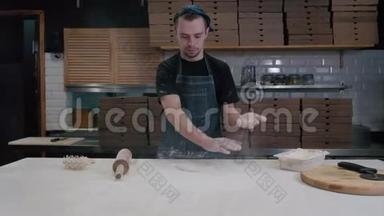 面包师用擀面杖把面团摊开，<strong>拍拍</strong>手，年轻的厨师做披萨送外卖